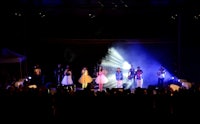 a group of people on stage in front of a blue light